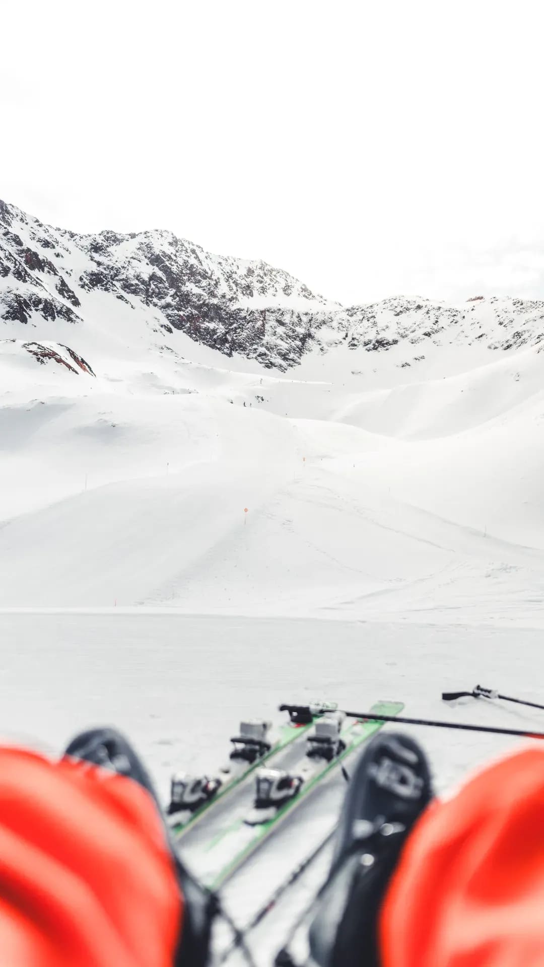Skispitzen im Vordergrund, verschneites Hochtal dahinter