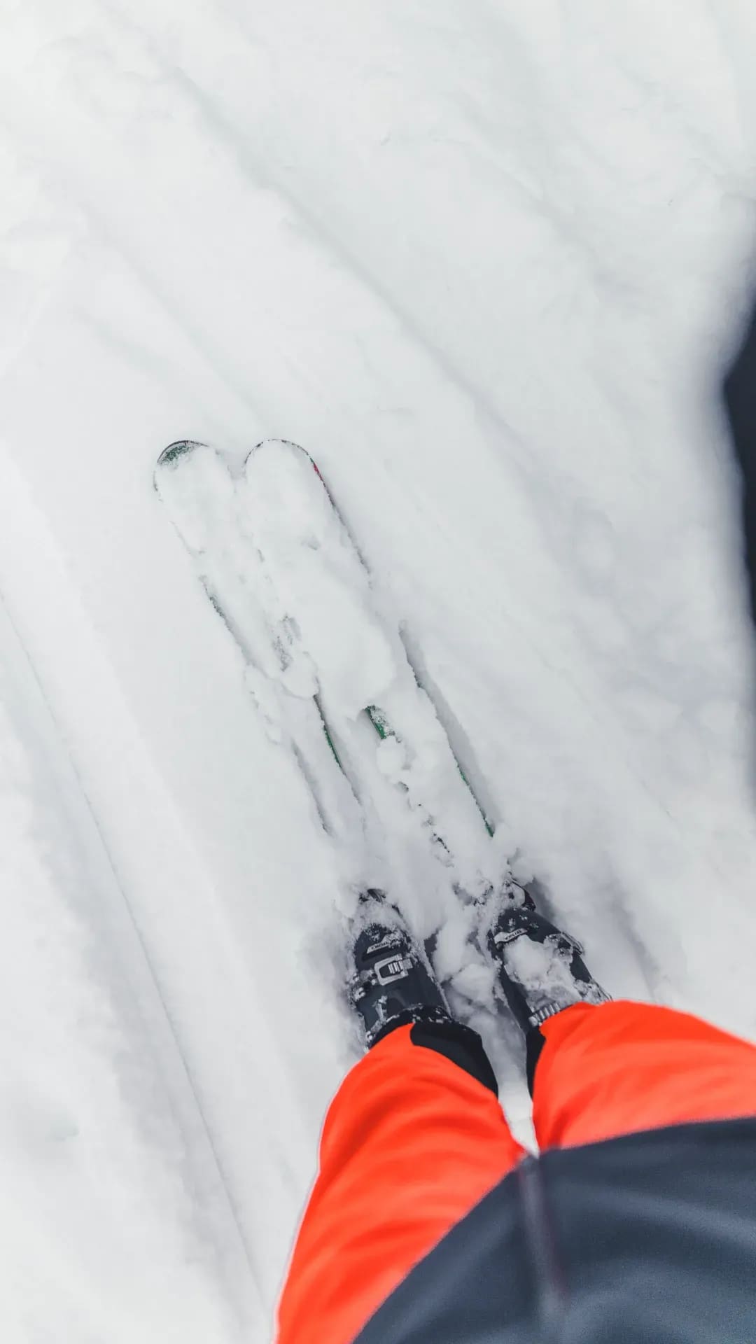 Blick nach unten auf die eigenen Ski im Schnee