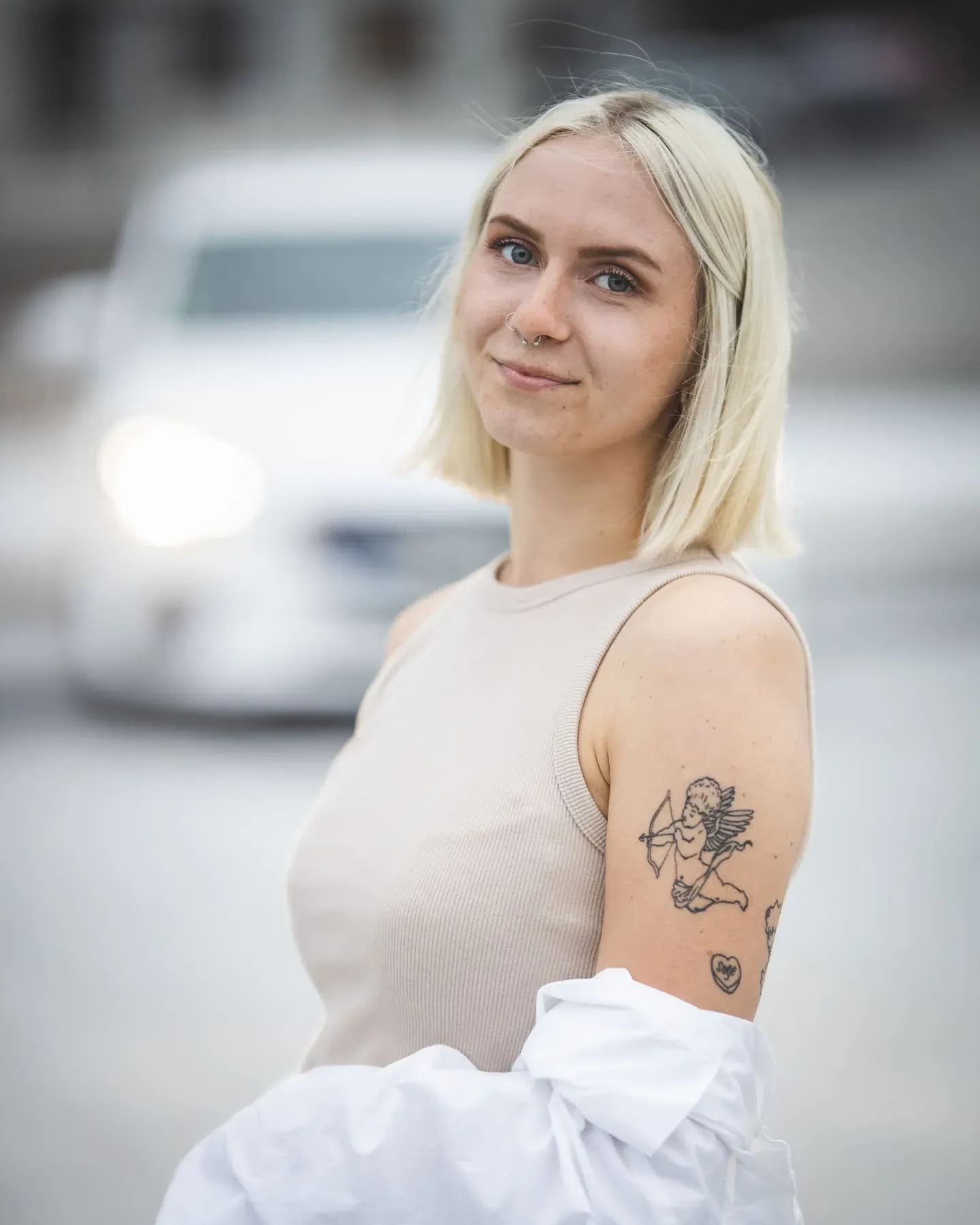 Blondes Porträt seitlich, unscharfes Auto im Hintergrund