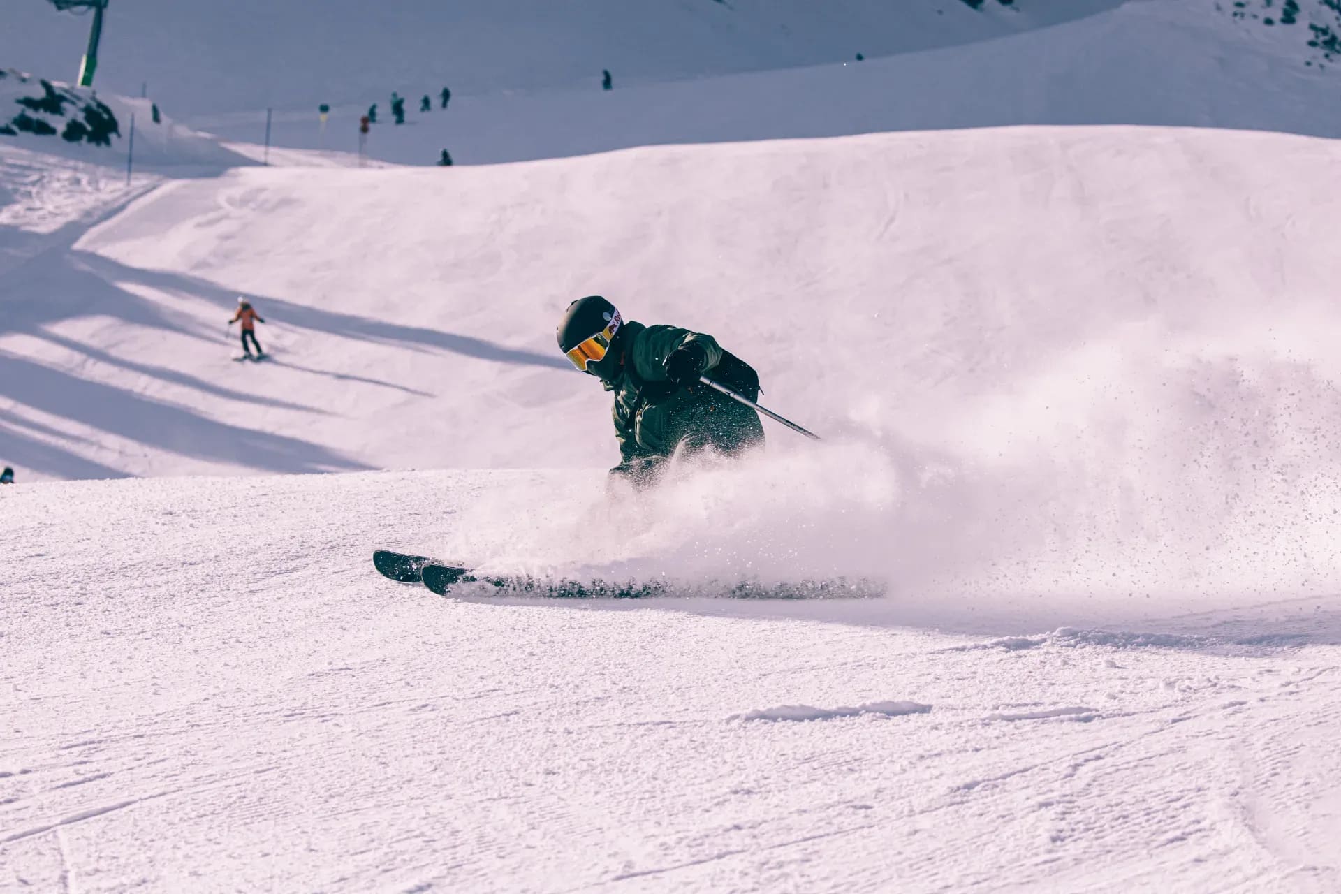 Skifahrer im Pulverschnee, ein zweiter Fahrer im Hintergrund