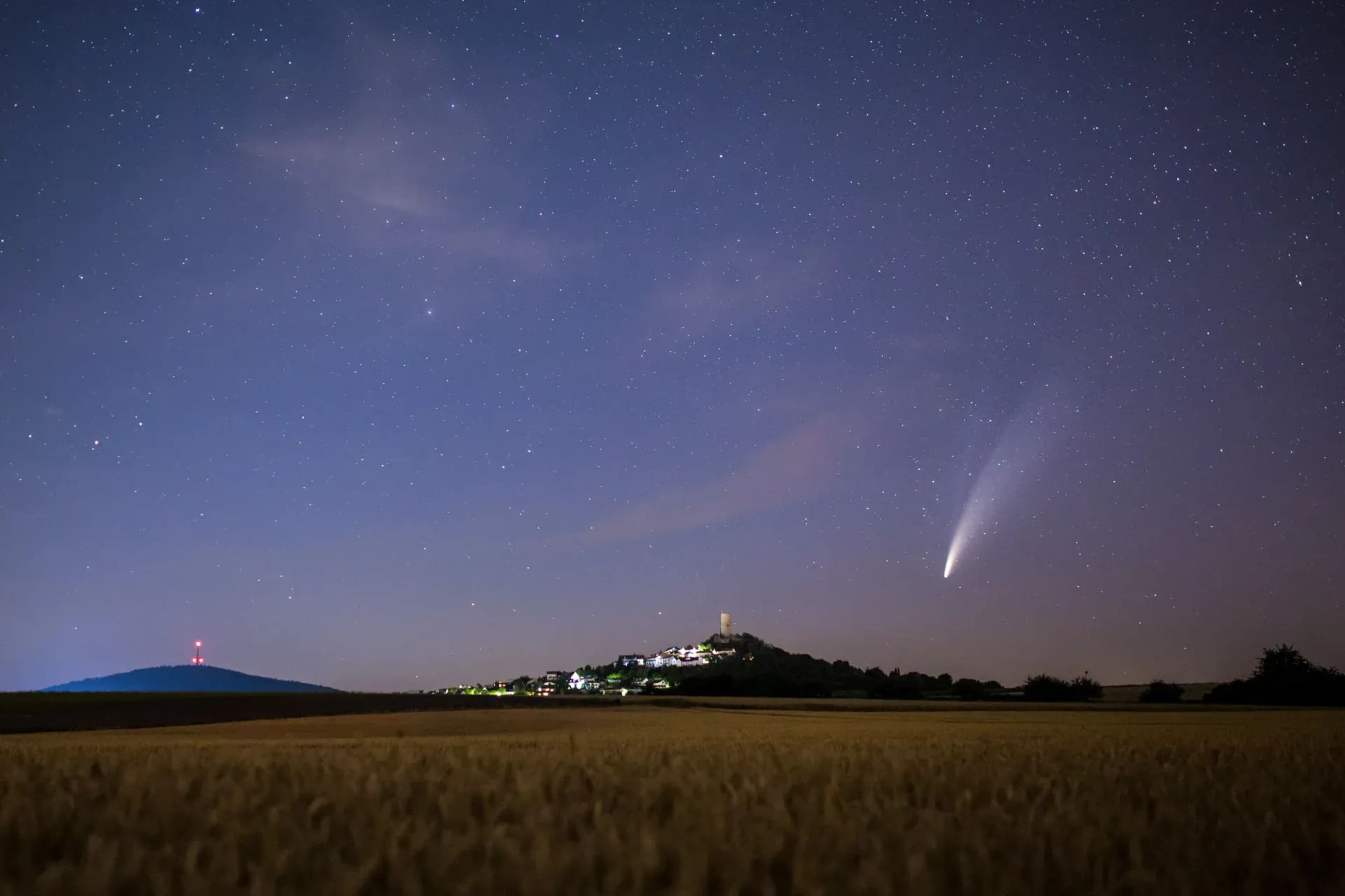 Komet Neowise über einem Kornfeld, Burg am Horizont