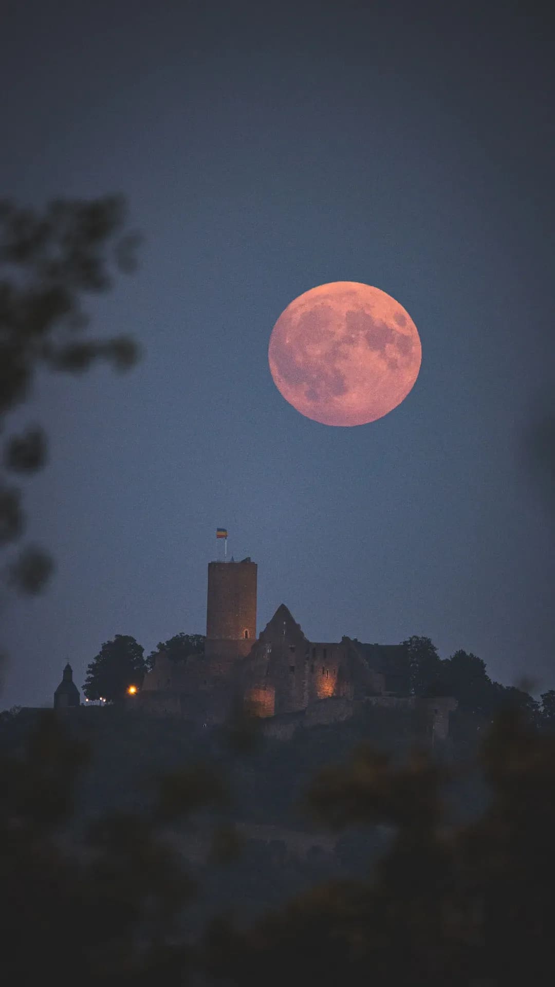 Aufgehender Vollmond hinter einer Burg