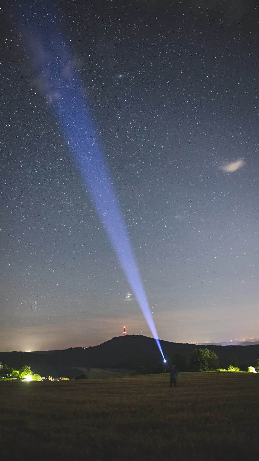 Lichtkegel einer Taschenlampe im Sternenhimmel