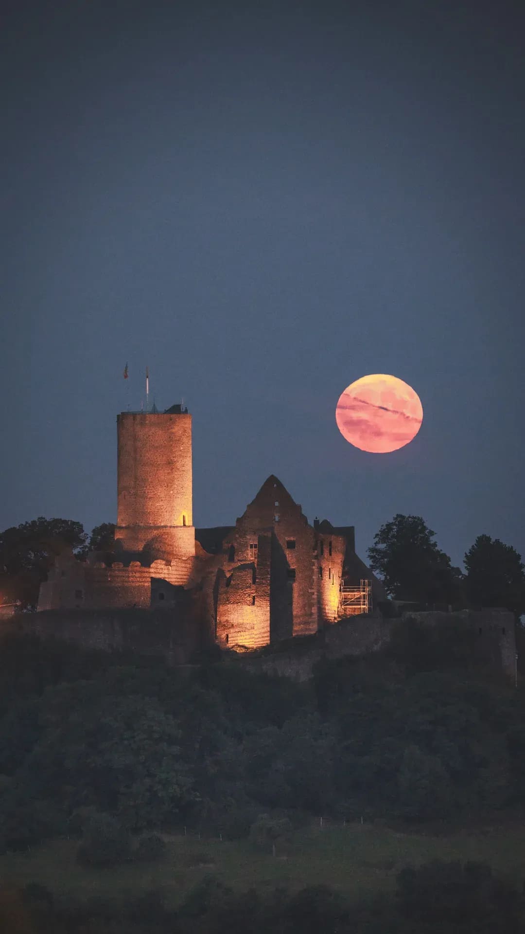 Aufgehender Mond hinter einer Burgruine