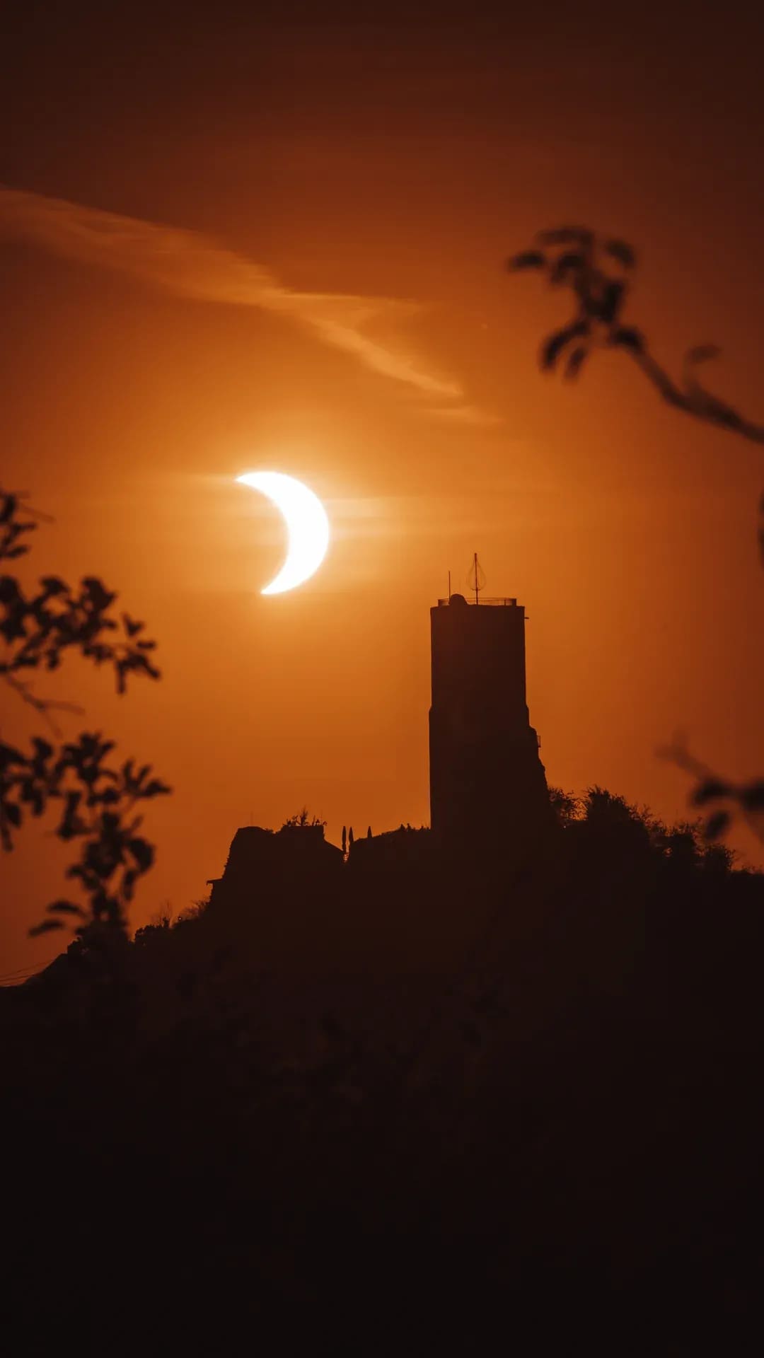 Sonnenfinsternis über der Silhouette einer Burgruine