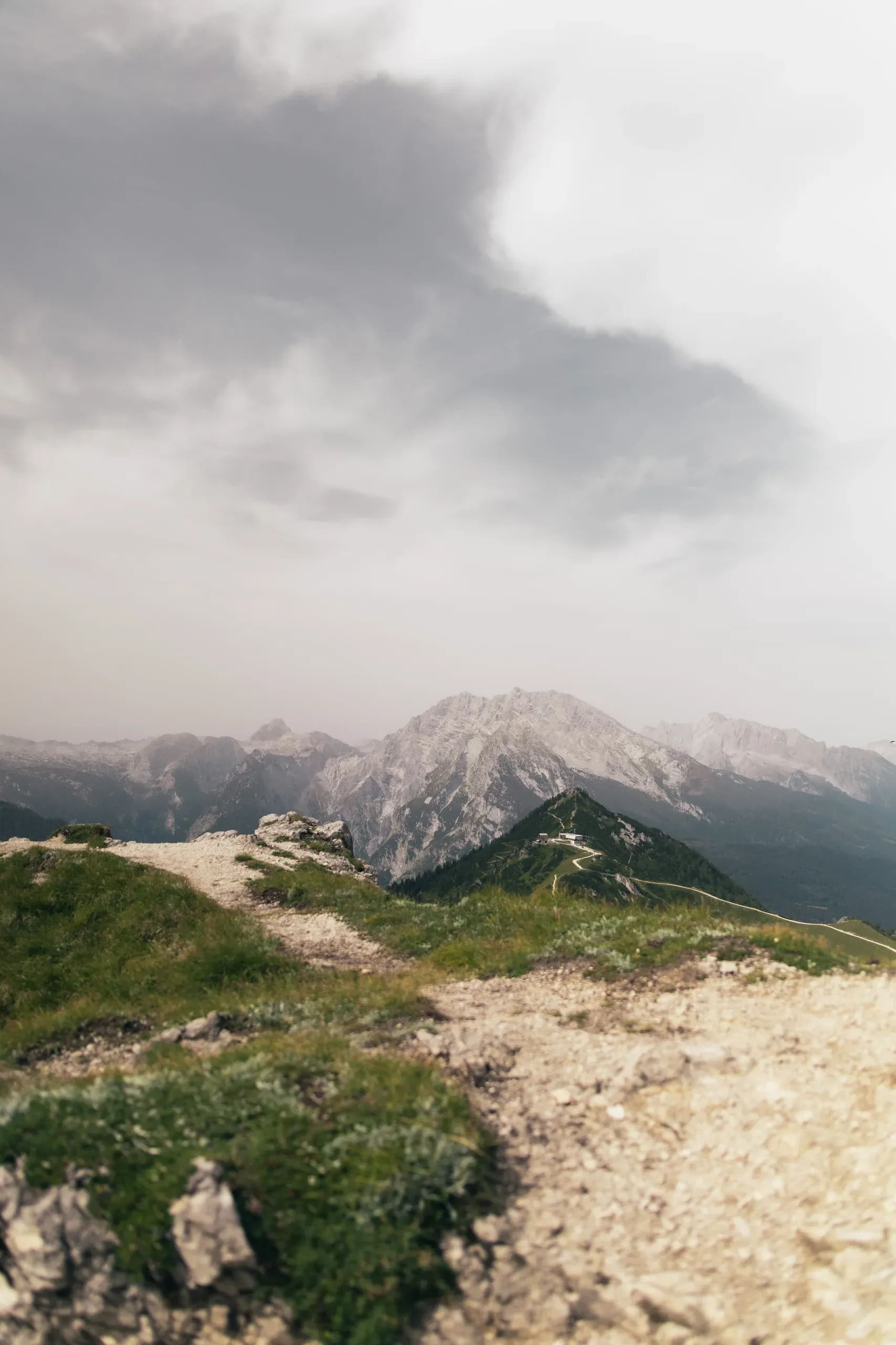 Dunkle Wolke über dem Grat, Schotterweg im Vordergrund
