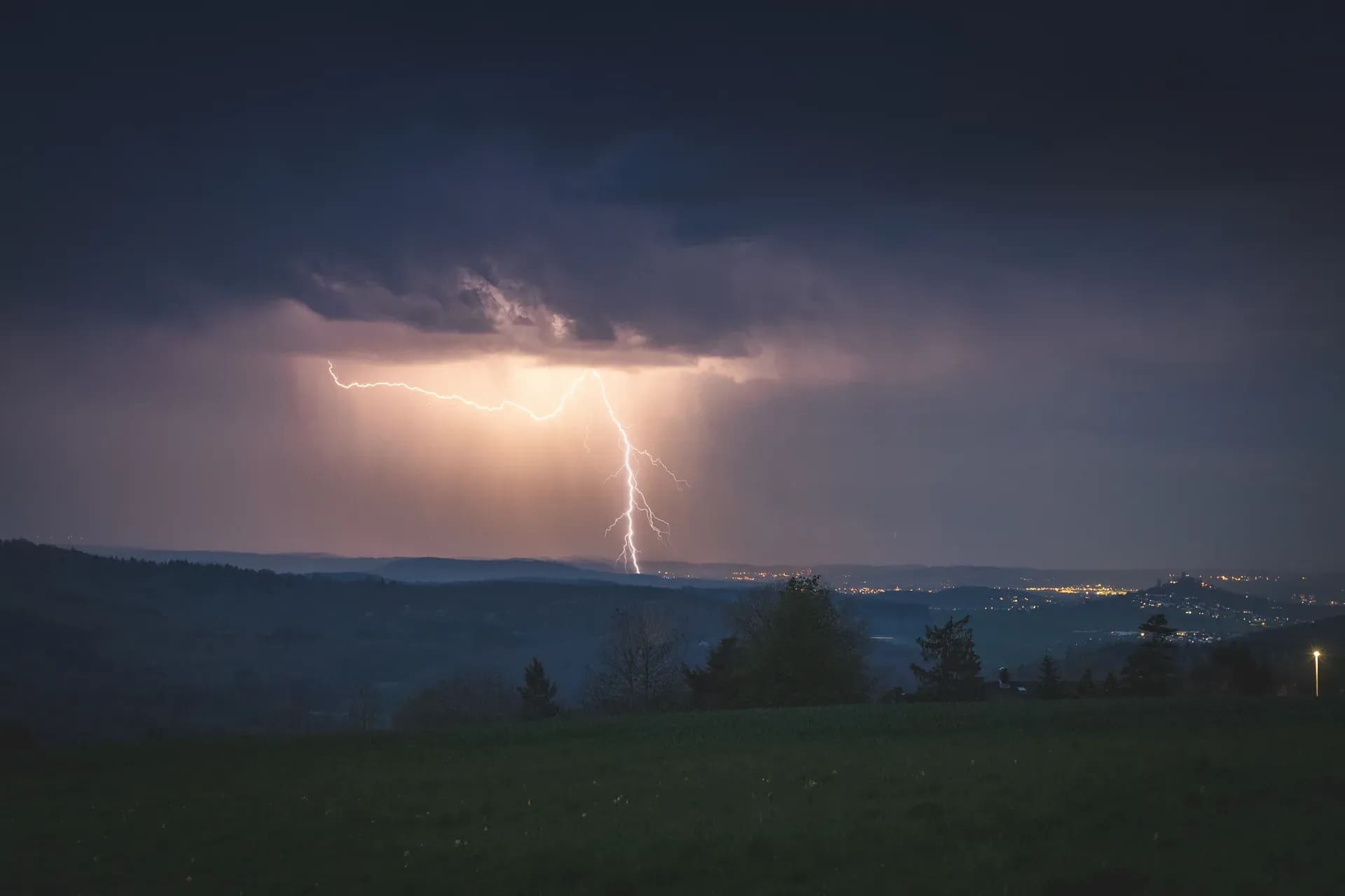 Blitzeinschlag über dem Tal in der Dämmerung