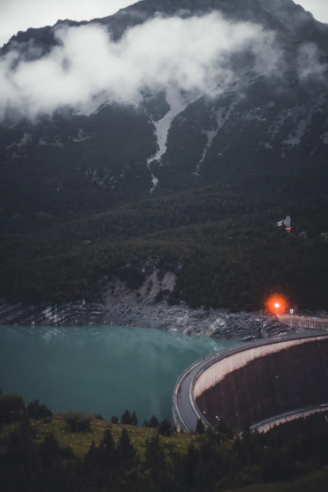 Staumauer über türkisem Stausee