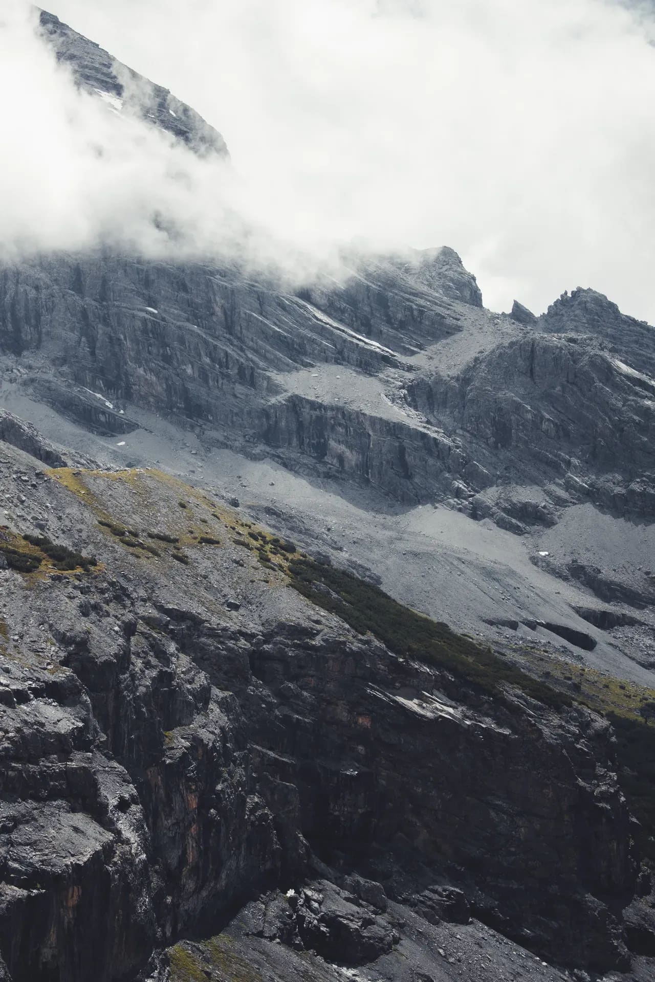 Verschneite Gipfel in tiefen Wolken