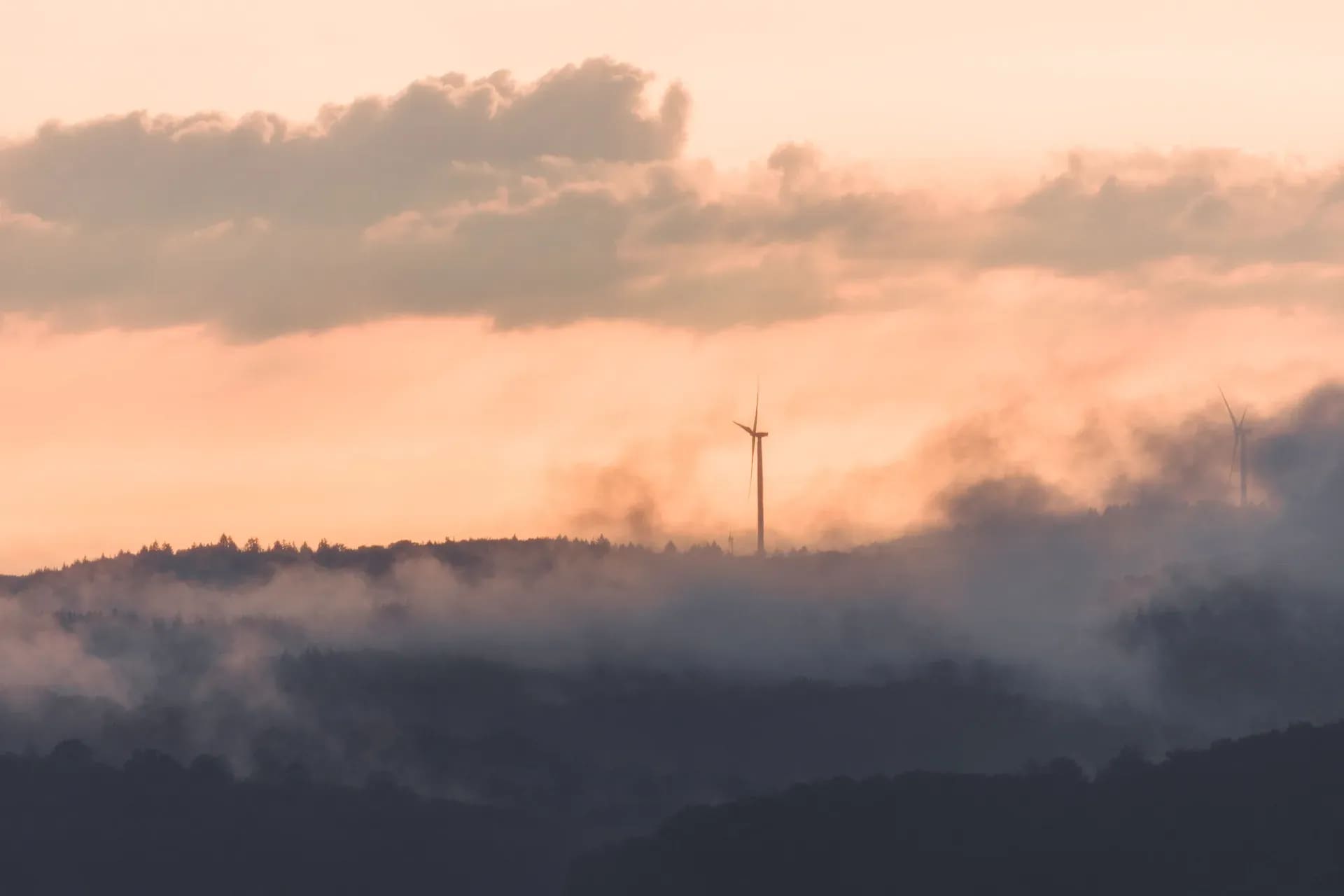 Windrad über einer Nebeldecke im Abendlicht