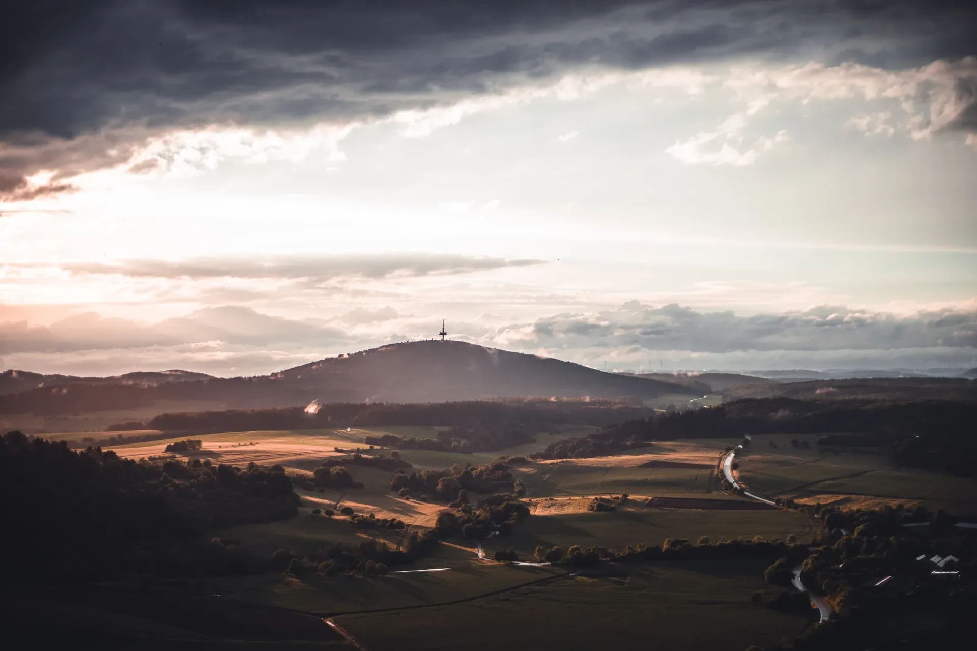 Hügellandschaft mit Sendeturm im Abendlicht