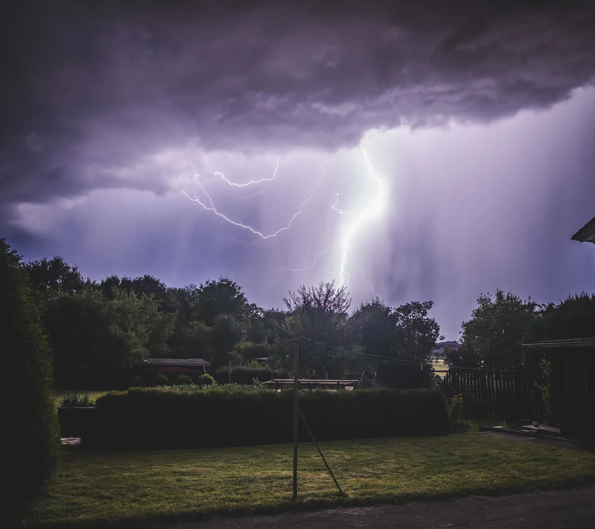 Blitz über einem Garten am Ortsrand