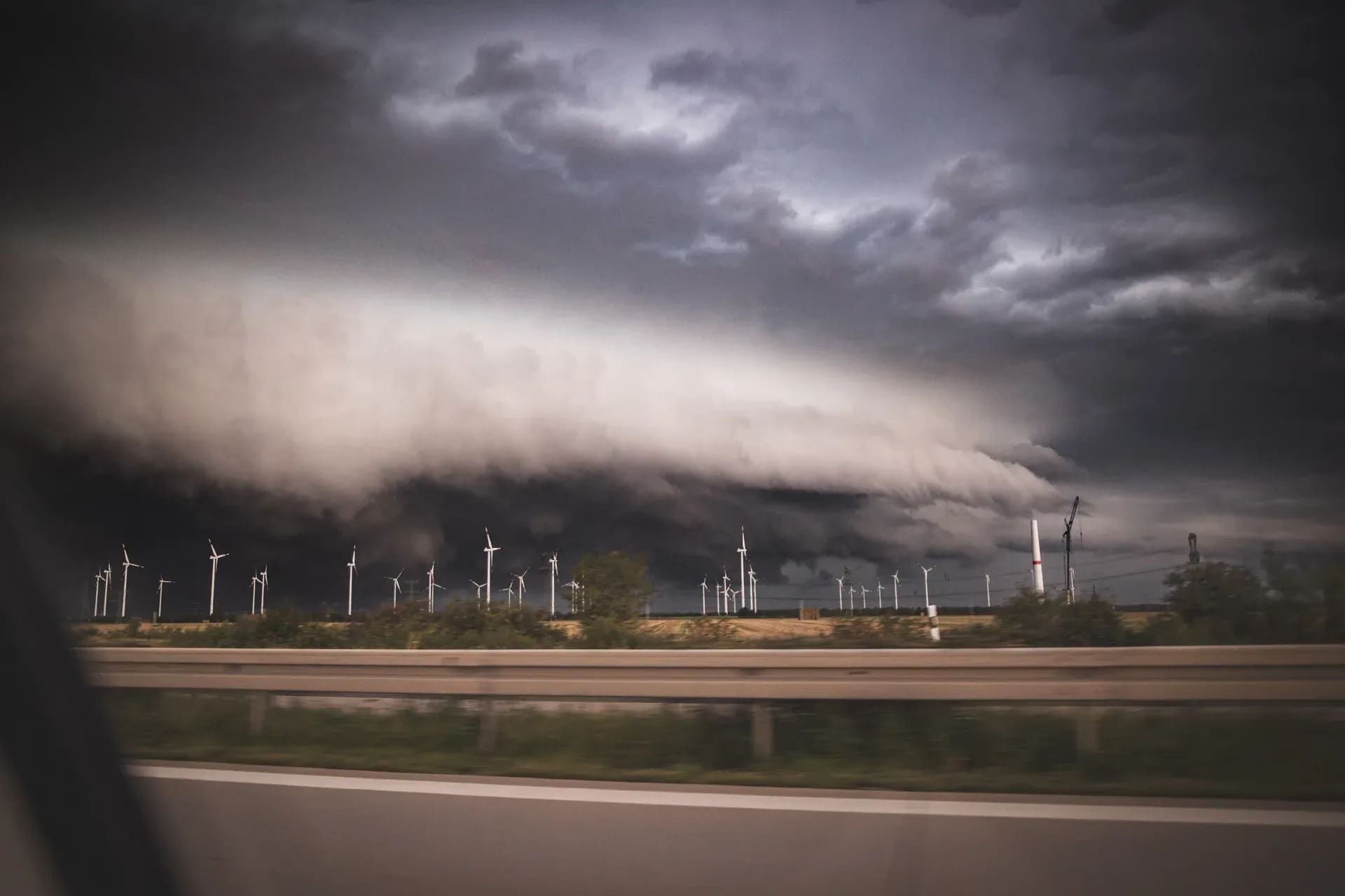 Böenwalze über einer Autobahn mit Windrädern