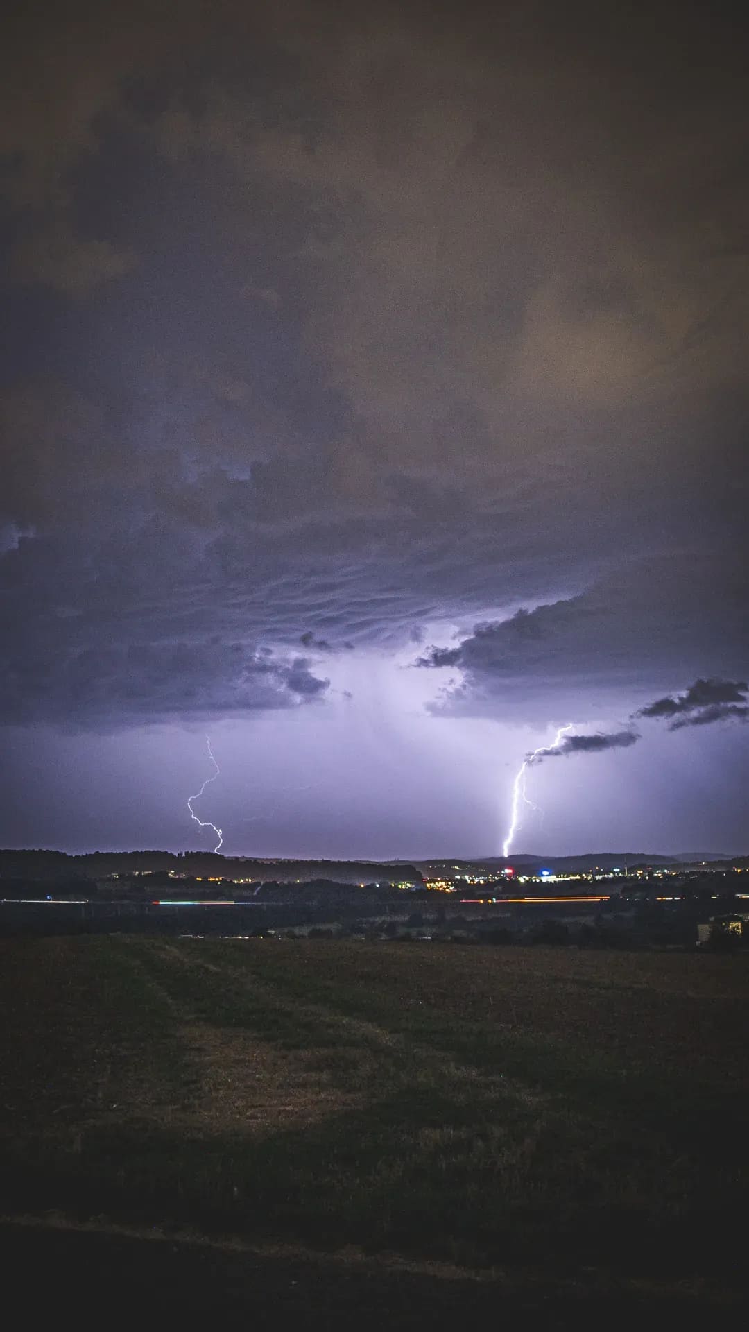 Blitze über Feldern in der Dämmerung